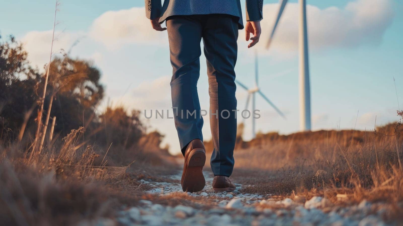 The picture of the person is working as business person walking to work near a grass and windmill, the businessman require skill like management, negotiation, marketing and the communication. AIG43.