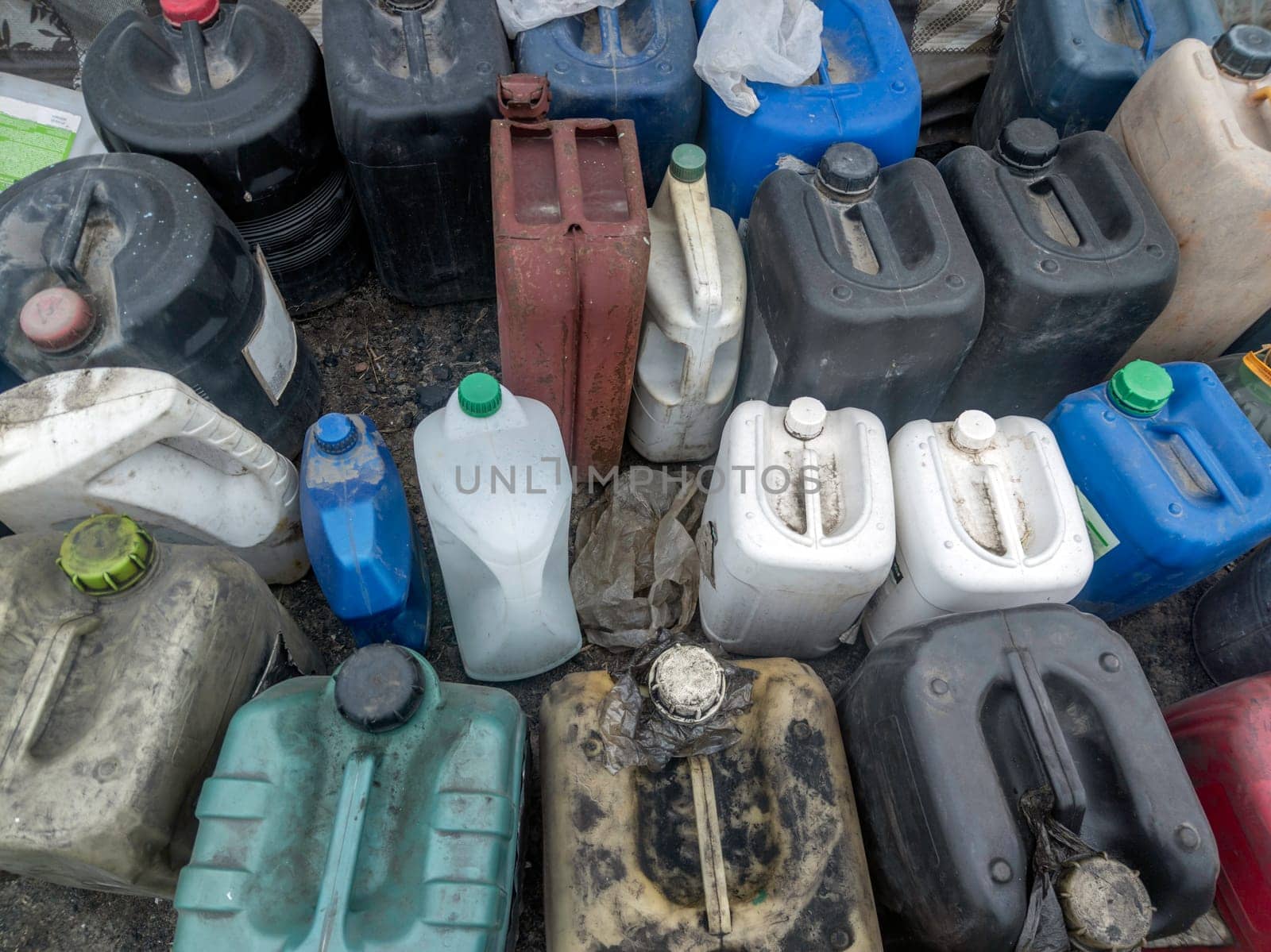 many used plastic containers standing closely on the ground