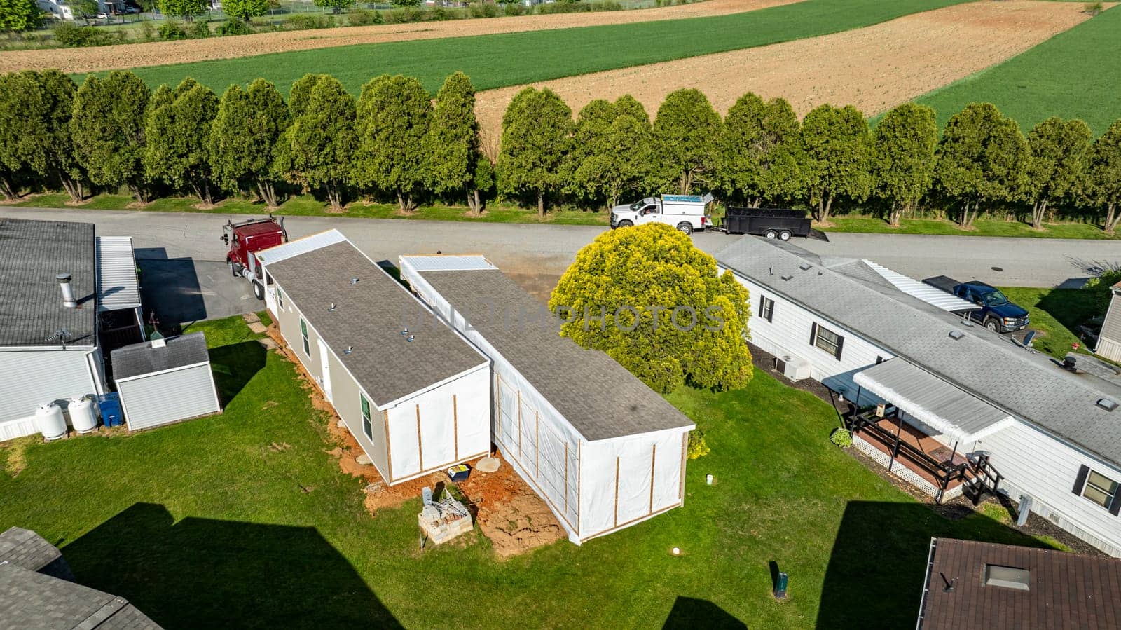 An Aerial View of a Manufactured, Mobile, Prefab Double Wide Home Being Installed in a Lot in a Park