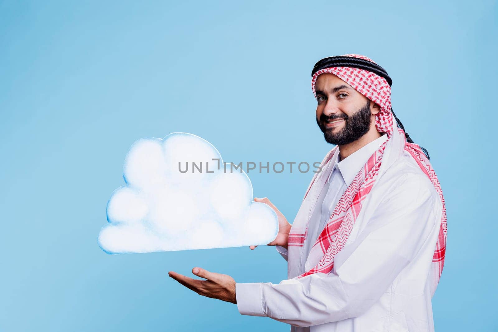 Cheerful arab man showing cloud shape by DCStudio