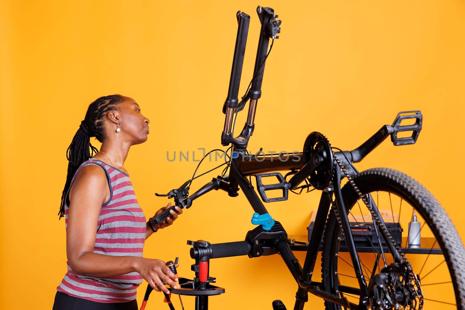 Woman examining bicycle front fork by DCStudio