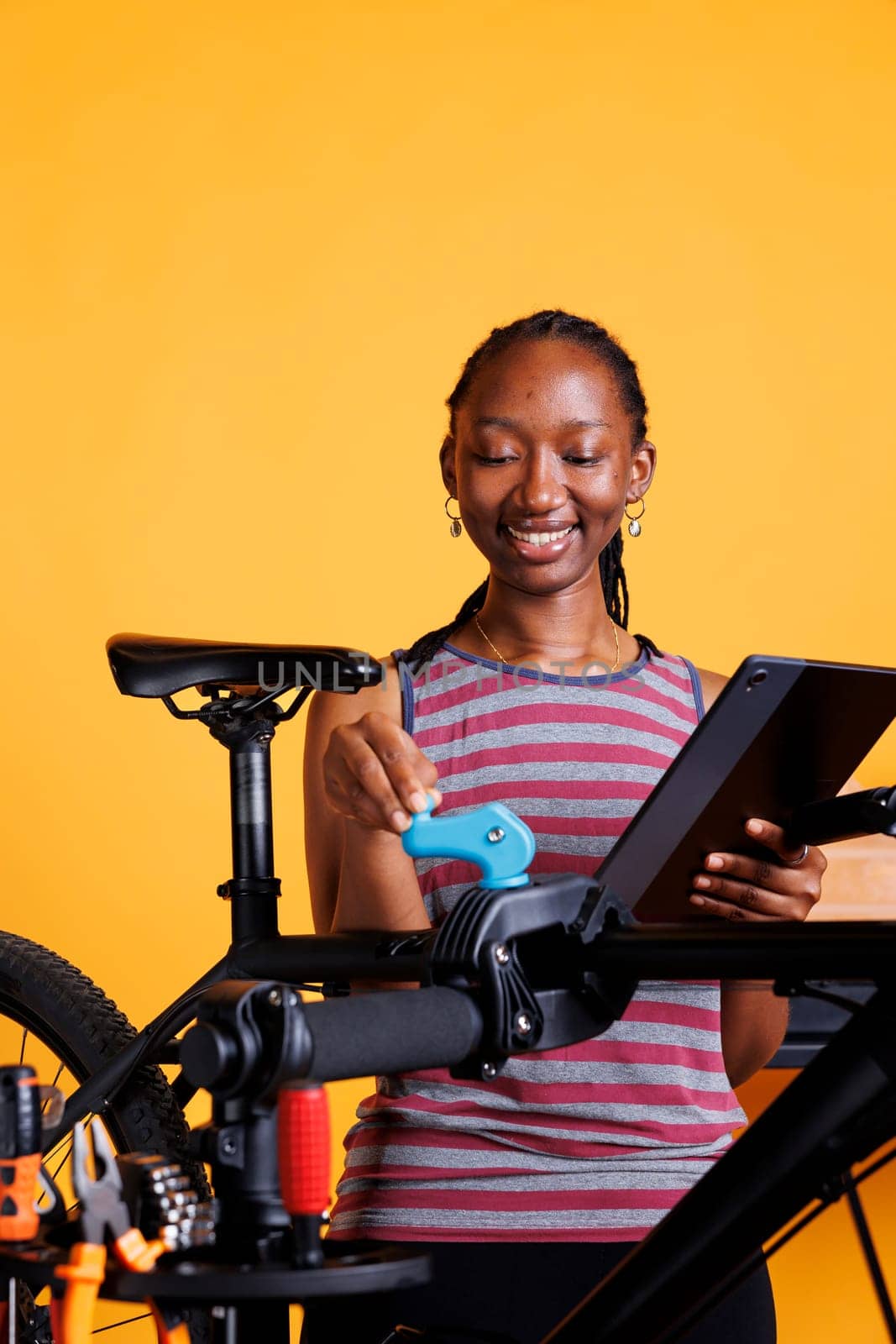 Lady with digital device for bike repair by DCStudio