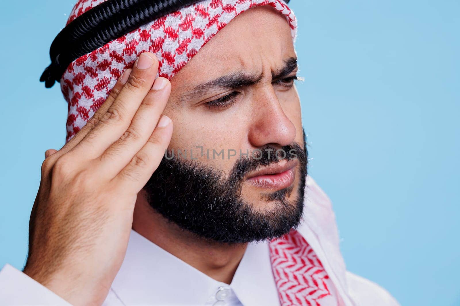 Muslim man having migraine symptom by DCStudio