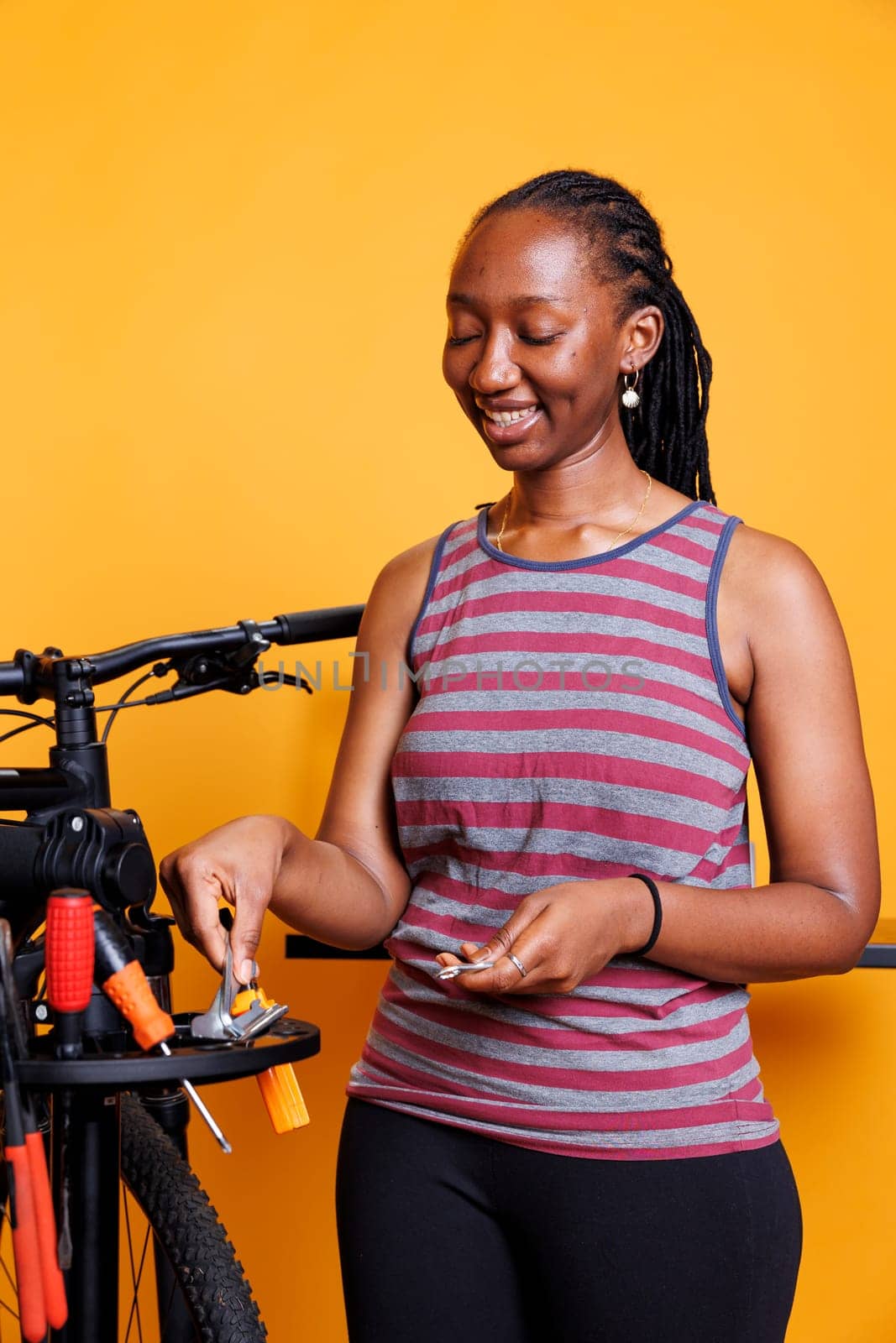 Black woman organizing tools for bicycle by DCStudio