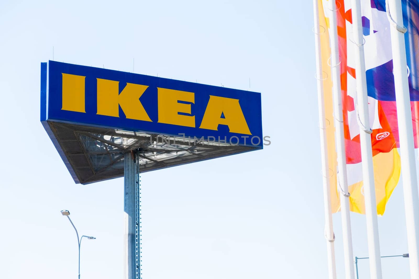 PRAGUE, CZECHIA -APRIL, 2024: IKEA mass market and flags against blue sky.