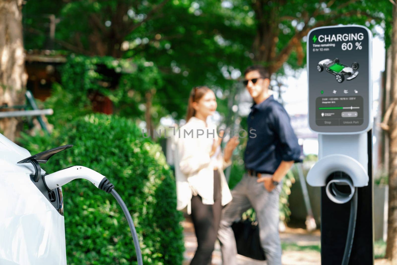 Young couple recharge electric car's battery from charging station. Expedient by biancoblue