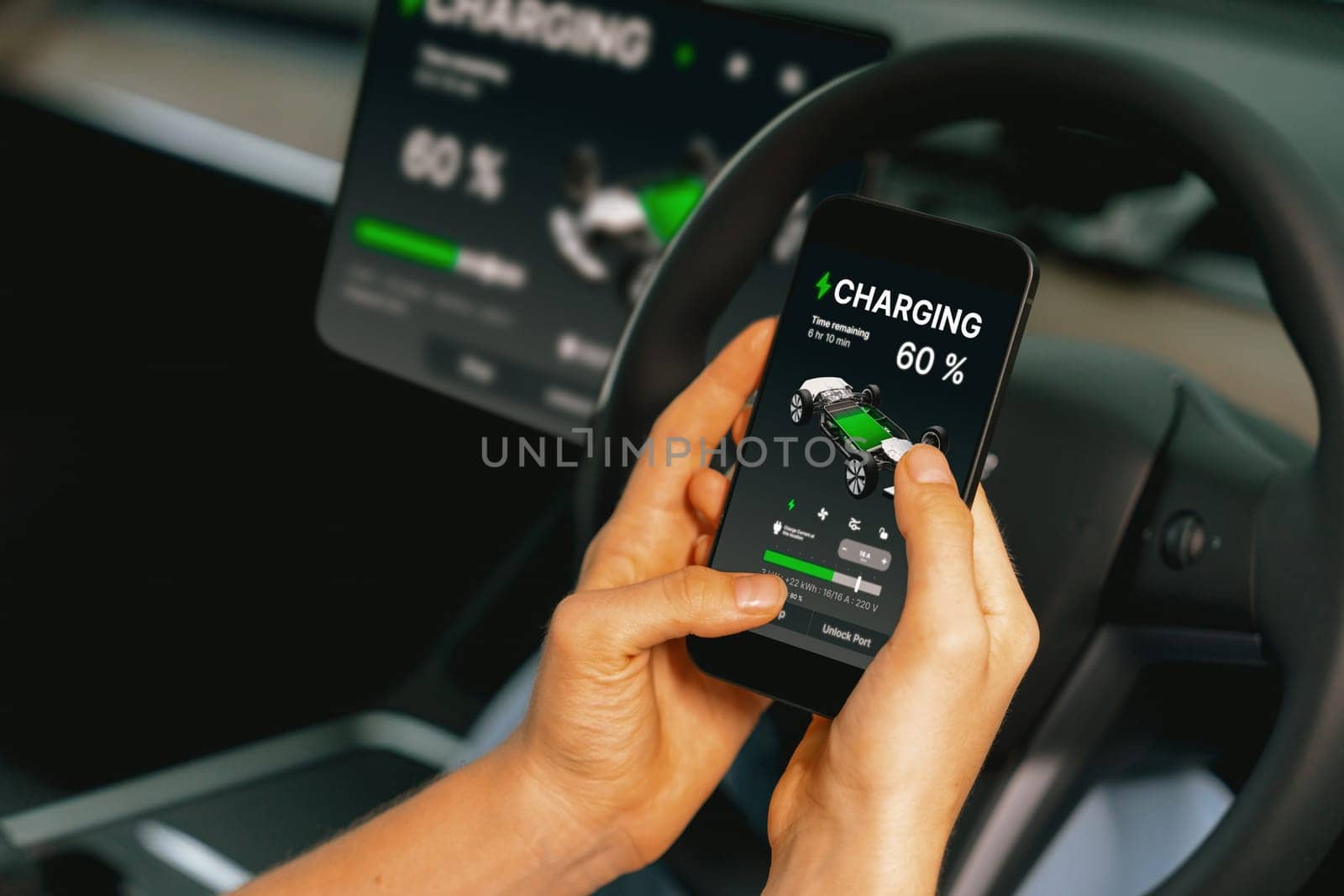 Young woman inside the vehicle, checking EV vehicle's application on battery recharging electricity status display on smartphone screen in modern EV car on her road trip journey. Exalt