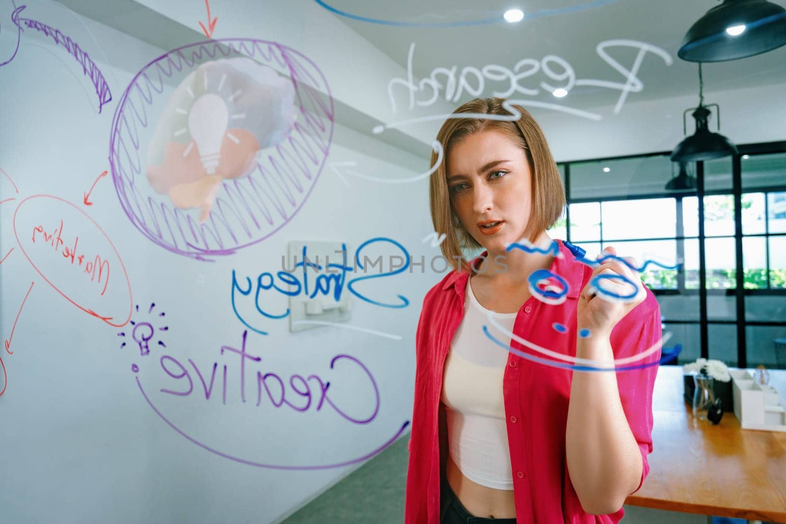 Closeup of attractive smart caucasian businesswoman brainstorms and planing marketing idea by using mind map and colorful sticker on glass board. Creative start up business concept. Immaculate.