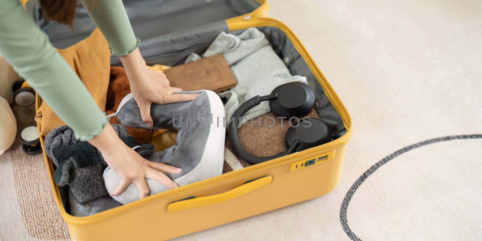 Happy Asian young woman packing suitcase at home. Preparing for summer holiday vacation abroad travel..