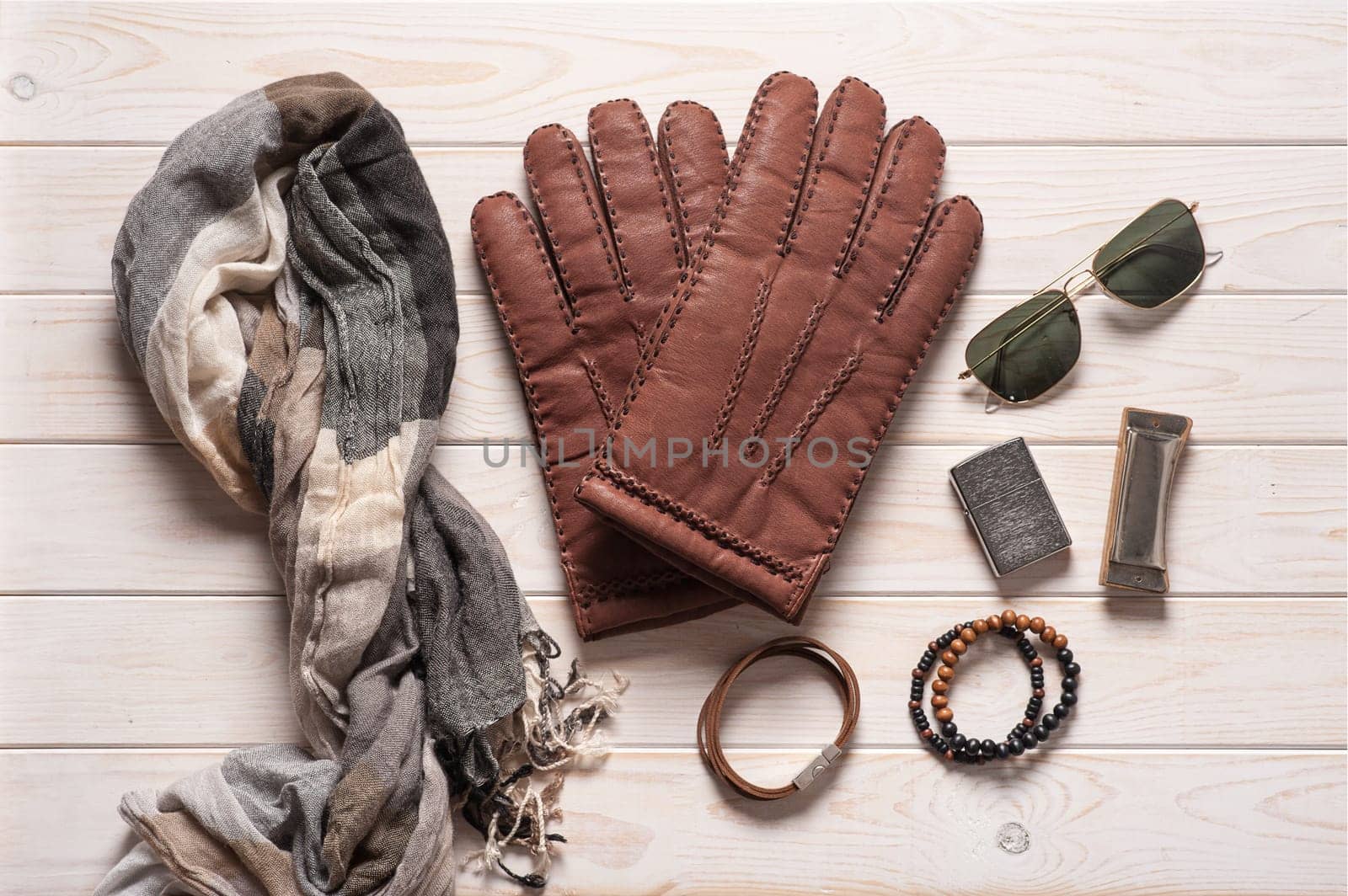 Pair of men's brown leather gloves and other men's accessories.