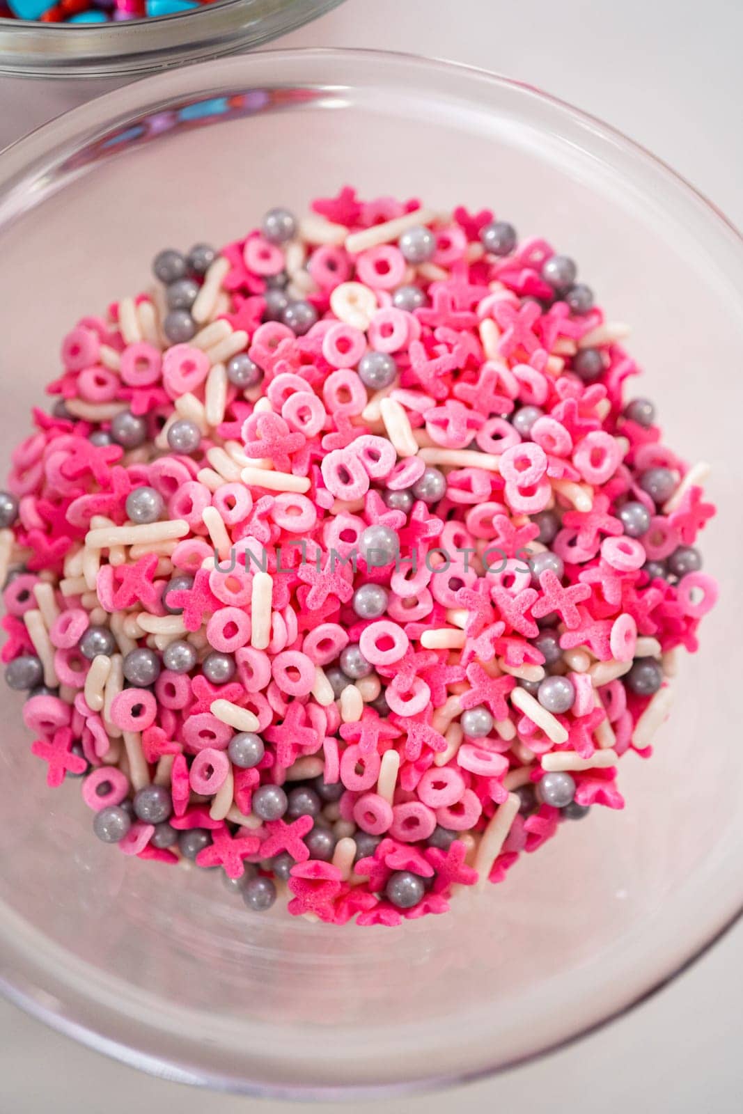 Measured ingredients in glass mixing bowls to make chocolate covered pretzel rods for Valentine's Day.