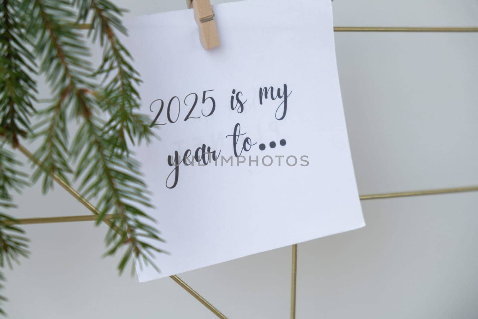 2025 IS MY YEAR TO text on white paper note on vision board with Christmas decor. New year aims resolutions. New me you concept visualizing by anna_stasiia