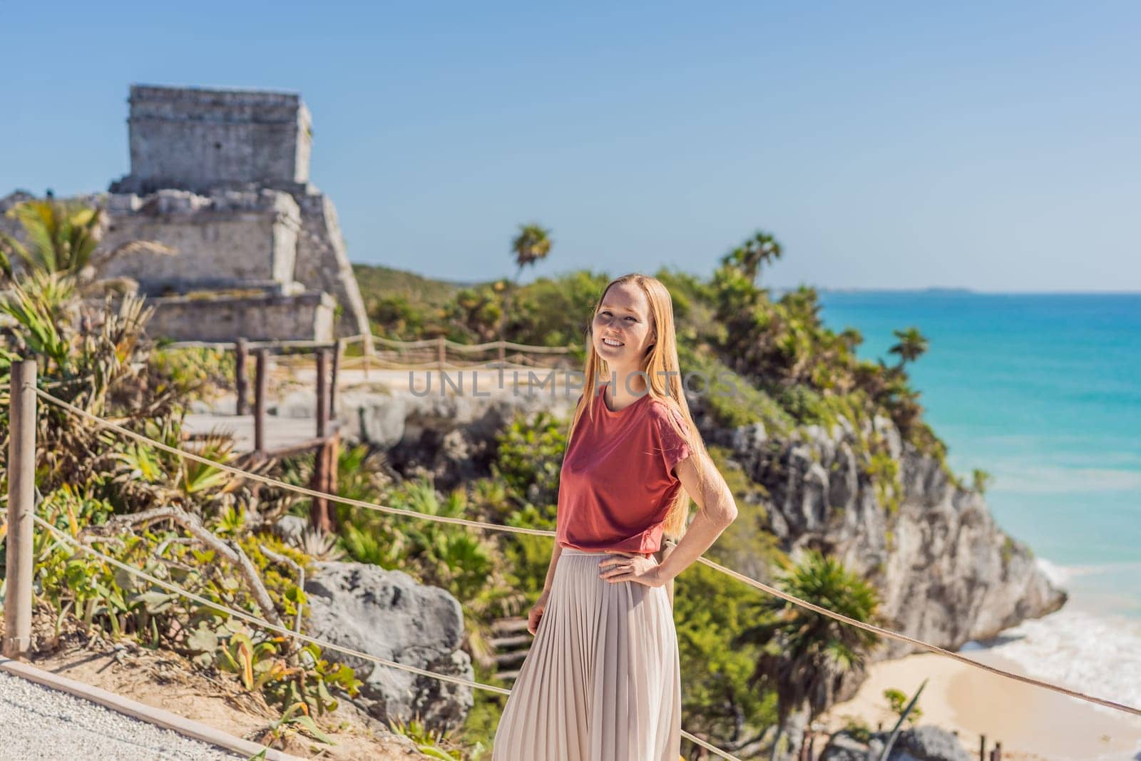 Woman tourist enjoying the view Pre-Columbian Mayan walled city of Tulum, Quintana Roo, Mexico, North America, Tulum, Mexico. El Castillo - castle the Mayan city of Tulum main temple.