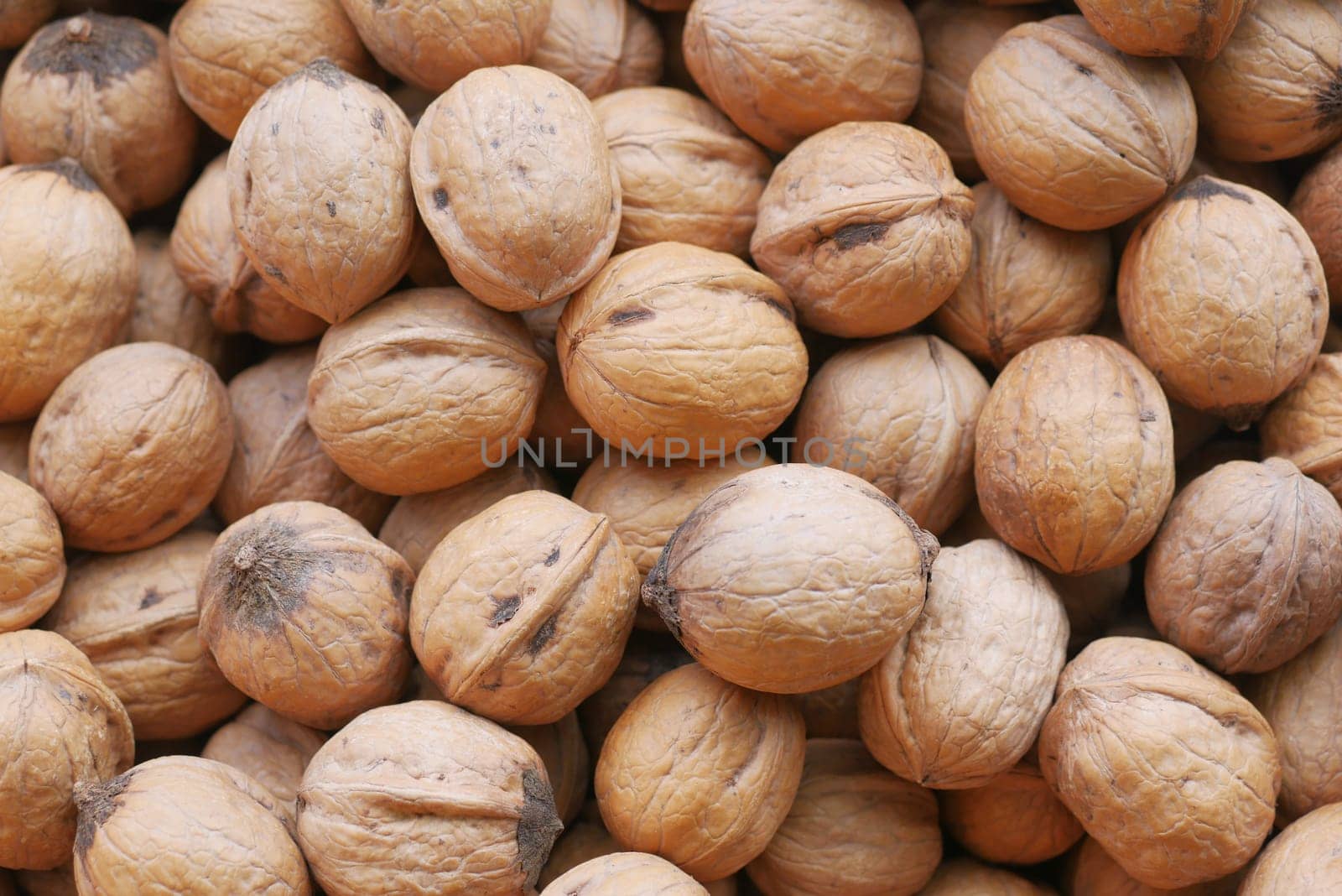 stack of natural walnuts selling at shop .