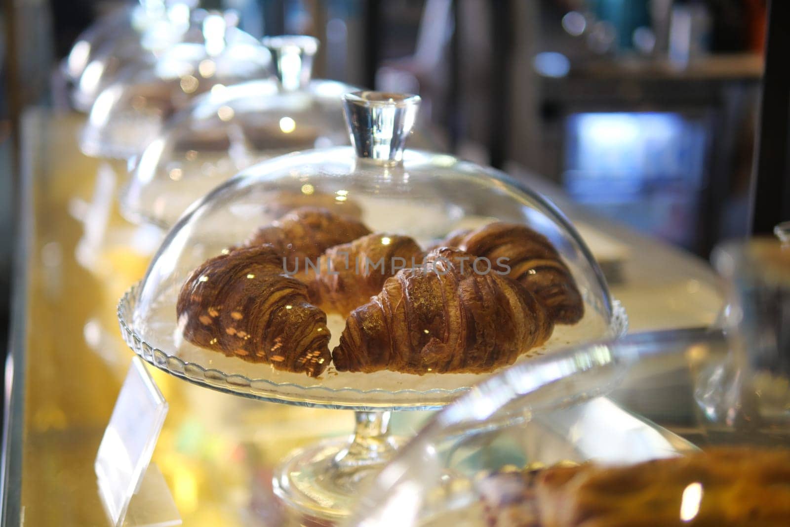 fresh baked croissant in a transparent jar at coffee shop .