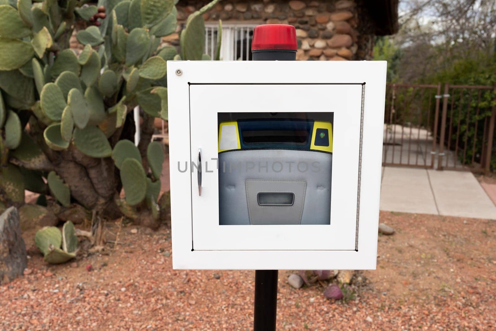 Aed, Life Saving Defibrillator In Street. Portable Automated External Defibrillator Outdoor. Cactus Is On Background. Prevention Of Heart Attack. Cardiac Healthcare. High quality photo