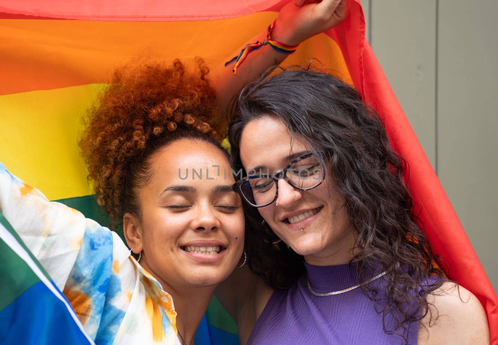 Headshot of lesbian multicultural couple calm with closed eyes enjoying the moment together by papatonic