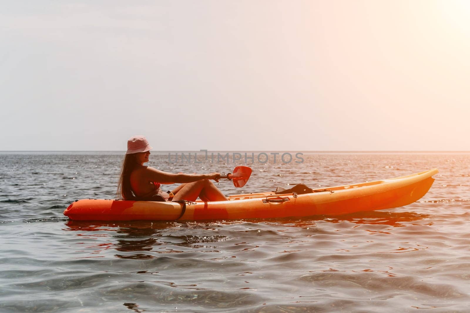 Woman sea kayak. Happy smiling woman paddling in kayak on ocean. Calm sea water and horizon in background. Active lifestyle at sea. Summer vacation. by panophotograph