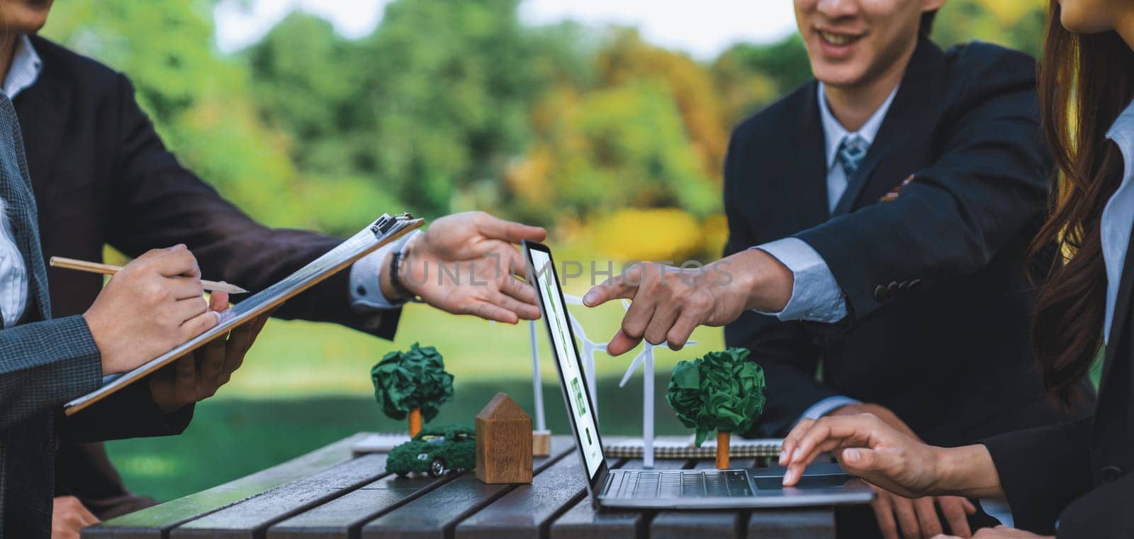 Group of asian business people presenting environmentally friendly development plan and sustainable technology project for greener future, establishing outdoor eco business office at natural park.Gyre