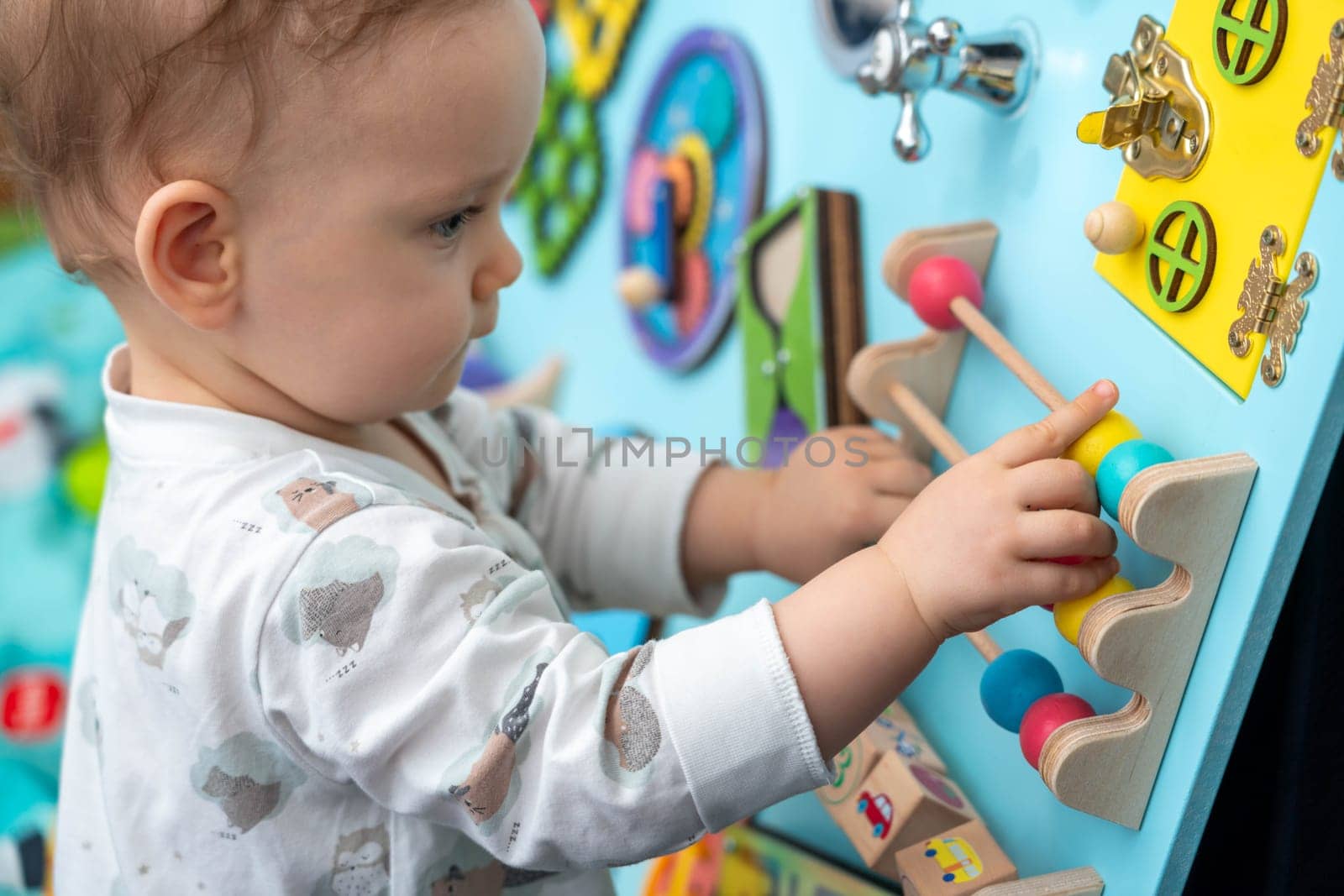 The girl is concentrating on moving various entertaining elements on the game board.