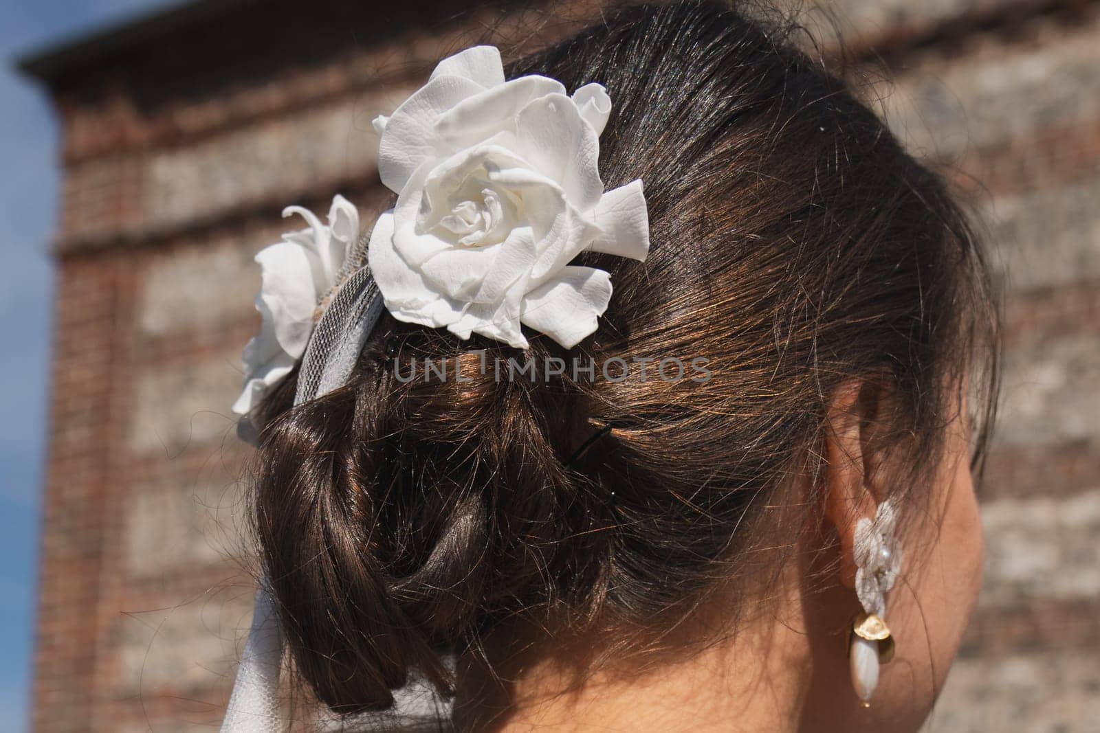 Brunette bride with a white rose in her hair