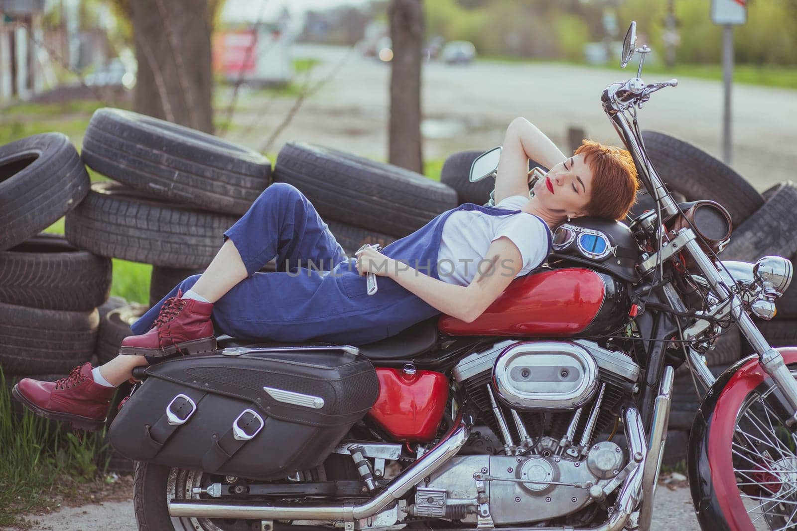 Beautiful girl mechanic on a motorcycle in a roadside workshop by Viktor_Osypenko