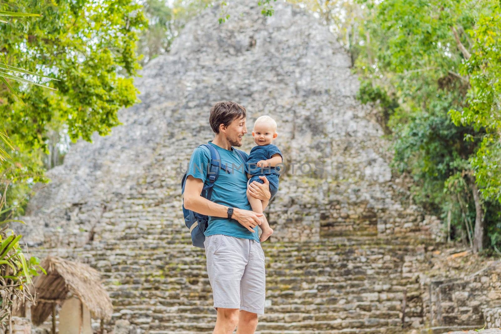 Dad and son tourists at Coba, Mexico. Ancient mayan city in Mexico. Coba is an archaeological area and a famous landmark of Yucatan Peninsula. Cloudy sky over a pyramid in Mexico by galitskaya