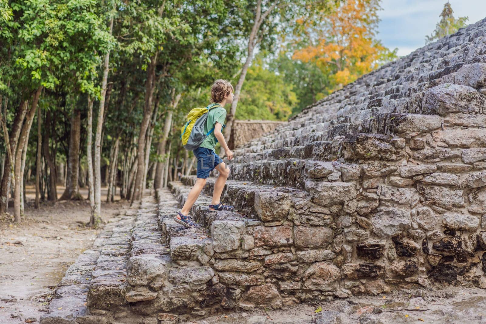 Boy tourist at Coba, Mexico. Ancient mayan city in Mexico. Coba is an archaeological area and a famous landmark of Yucatan Peninsula. Cloudy sky over a pyramid in Mexico by galitskaya