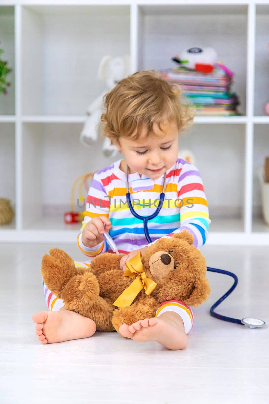 The child treats the bear plays. Selective focus. Kid.