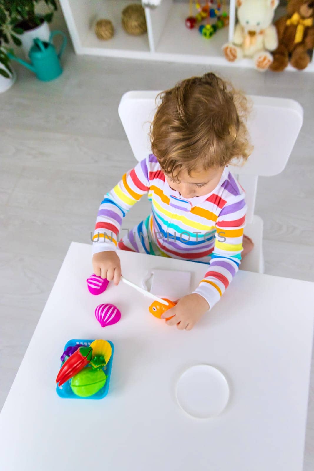 Child plays kitchen and food toys. Selective focus. Kid.