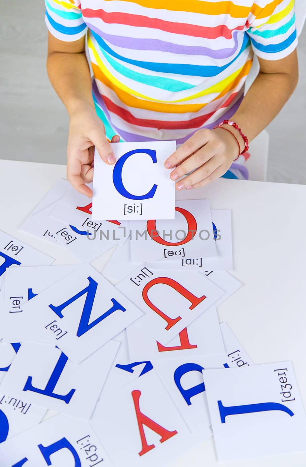 The child learns English letters. Selective focus. Kid.