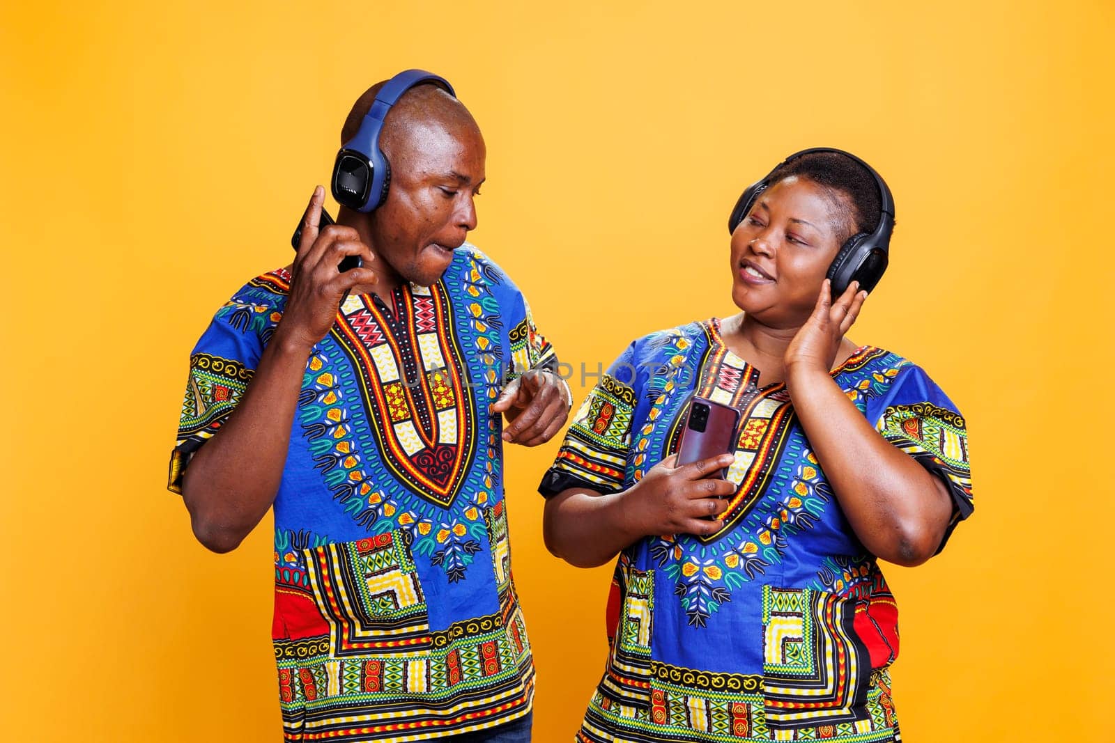 Smiling black couple listening to music by DCStudio