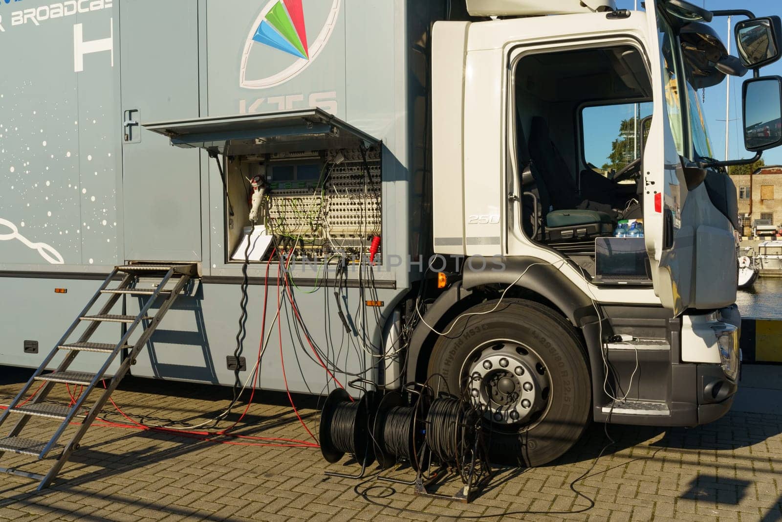Klaipeda, Lithuania - August 11, 2023: A live broadcast truck with its side panel open, revealing screens and equipment for television production, standing ready for a live event coverage.