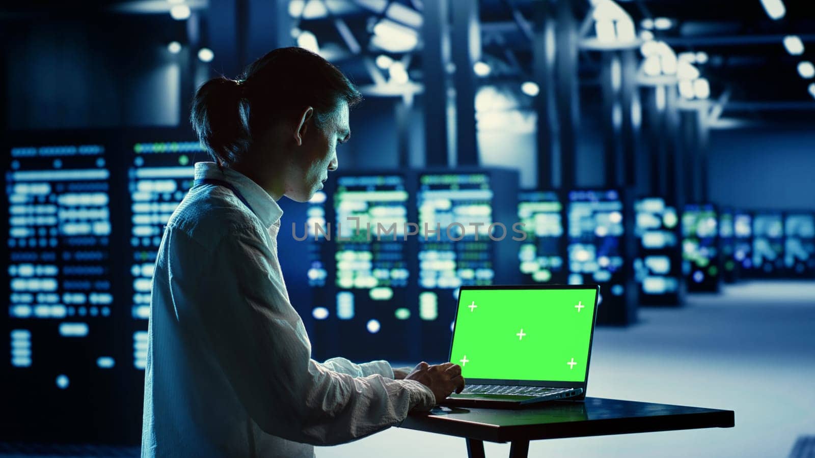 IT consultant running code on chroma key laptop, troubleshooting data center equipment. Cloud computing business executive using green screen device to examine servers and networking systems