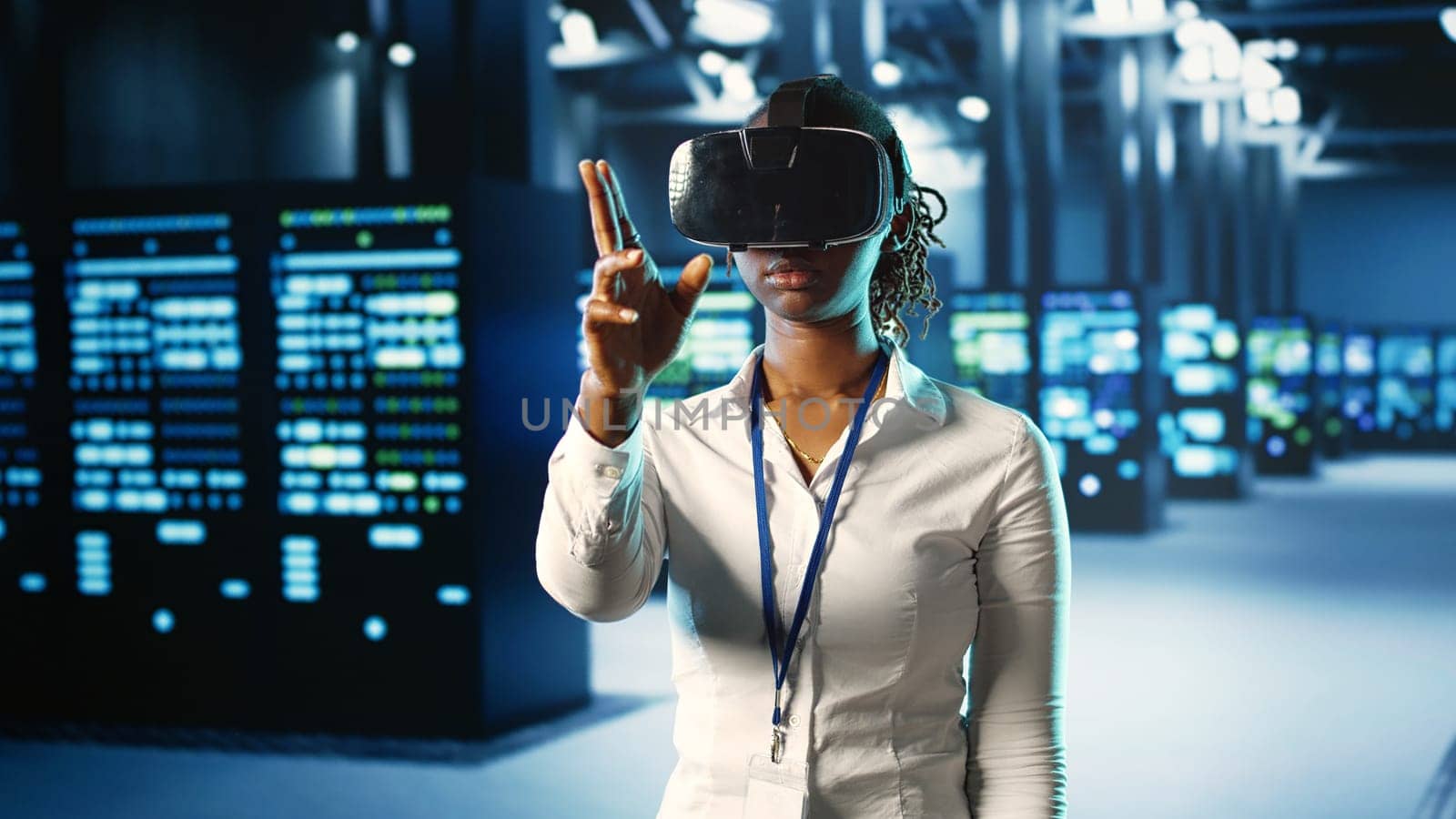 African american woman immersed in virtual reality at data center, doing equipment maintenance. Qualified engineer using VR headset to optimize server equipment performance, checking operations