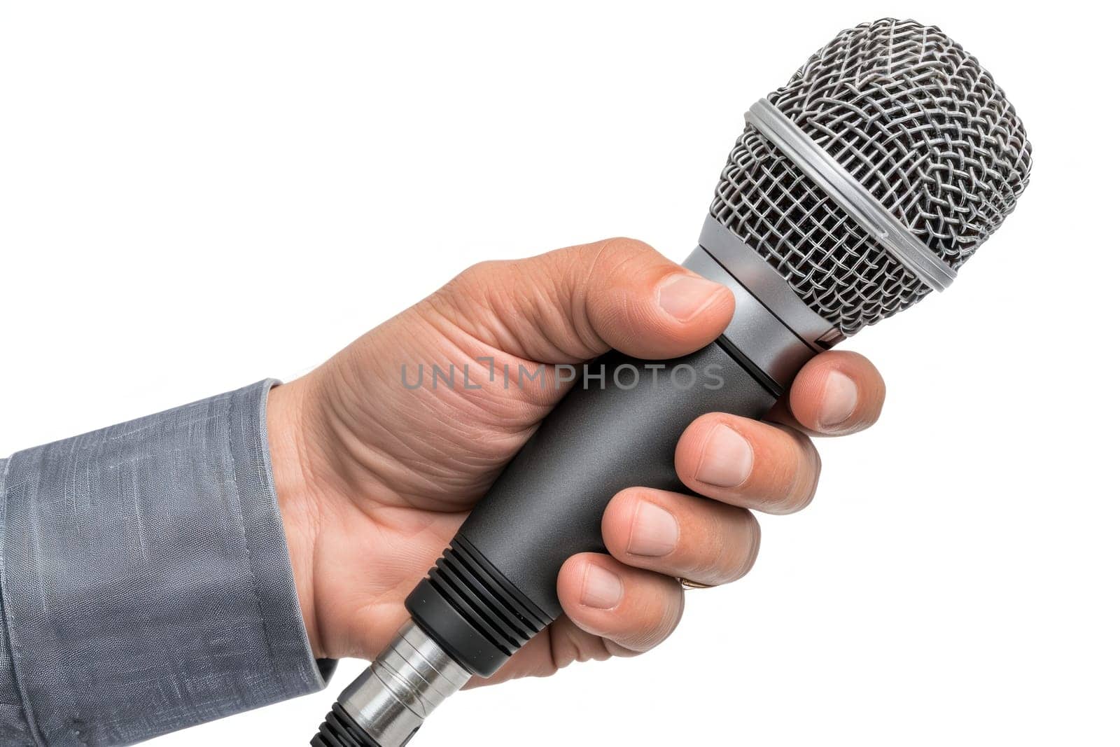 A microphone is being held by a person's hand. The microphone is silver and black. The person is holding the microphone in a way that it is facing forward