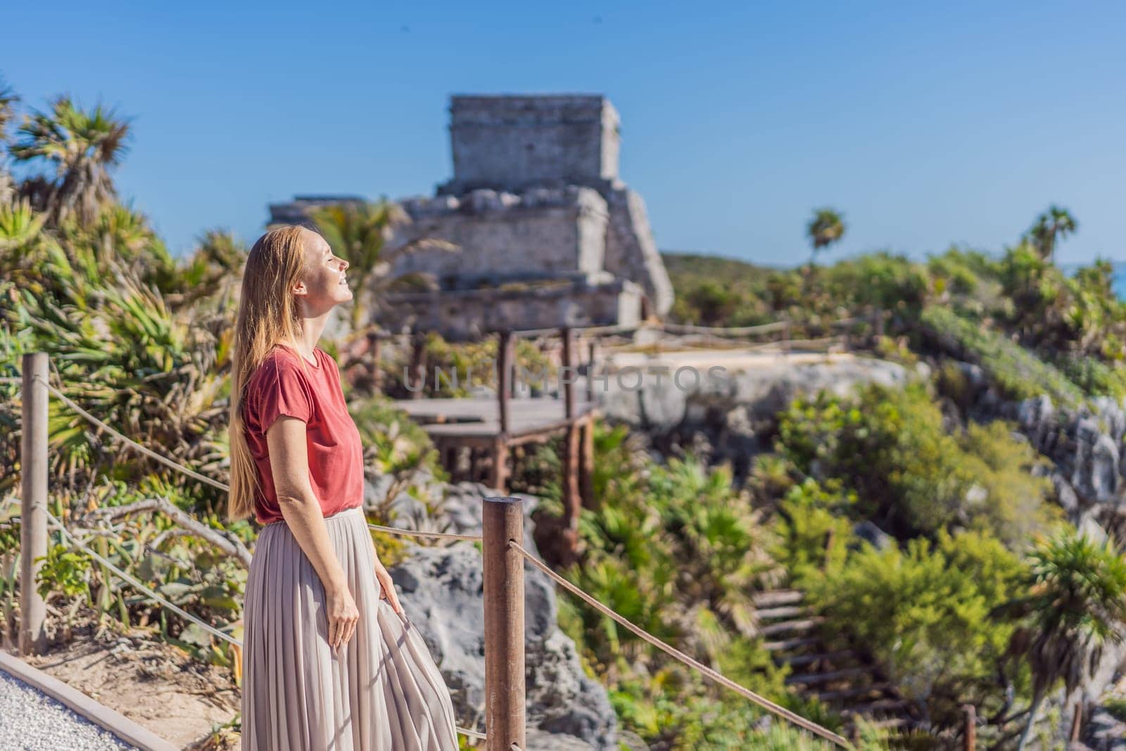 Woman tourist enjoying the view Pre-Columbian Mayan walled city of Tulum, Quintana Roo, Mexico, North America, Tulum, Mexico. El Castillo - castle the Mayan city of Tulum main temple by galitskaya