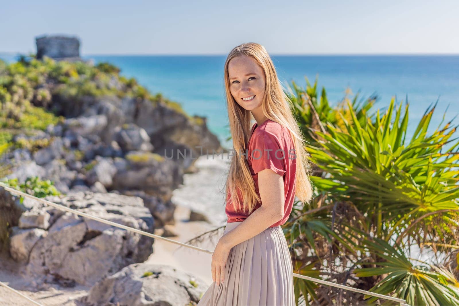 Woman tourist enjoying the view Pre-Columbian Mayan walled city of Tulum, Quintana Roo, Mexico, North America, Tulum, Mexico. El Castillo - castle the Mayan city of Tulum main temple by galitskaya