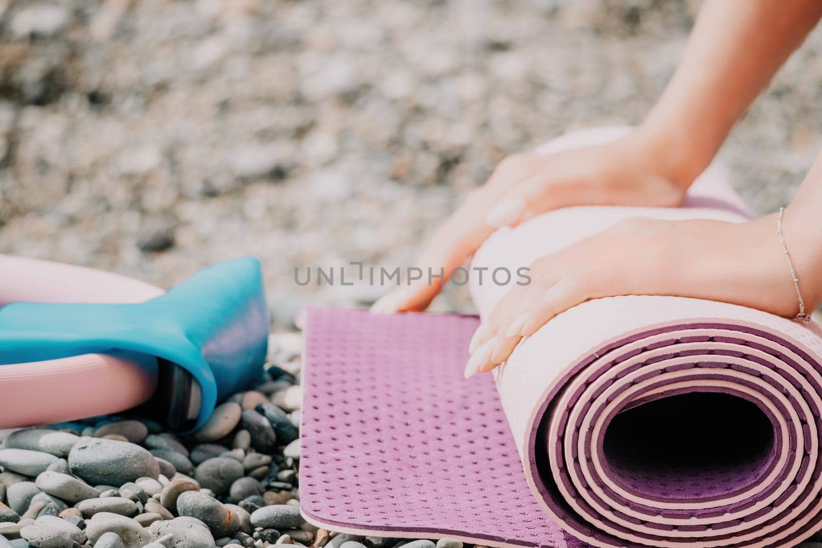 Pilates magic ring and rubber band on yoga mat near sea. Female fitness yoga concept. Healthy lifestyle harmony and meditation. by panophotograph