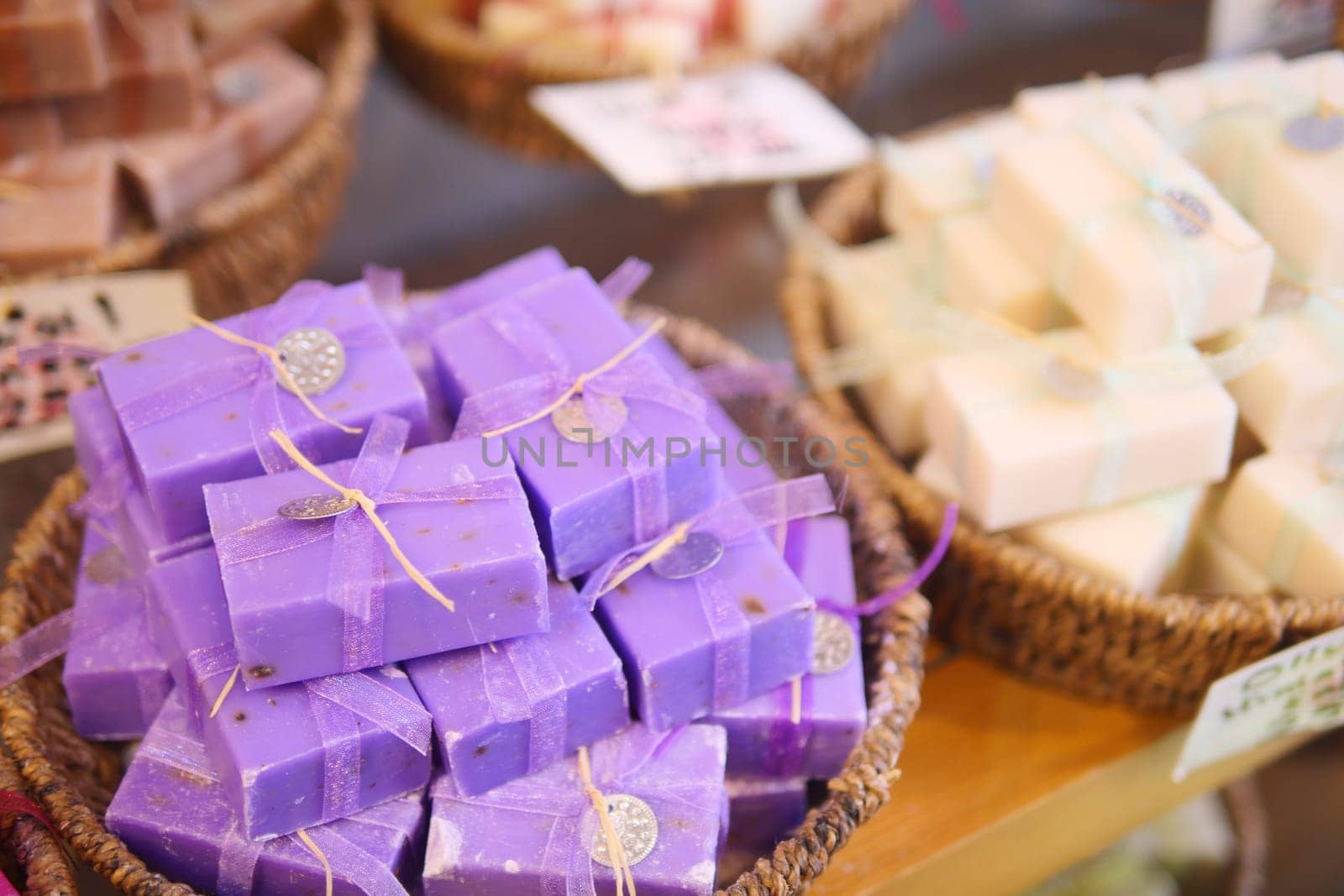 A stack of purple soaps with blue ribbons in a basket by towfiq007