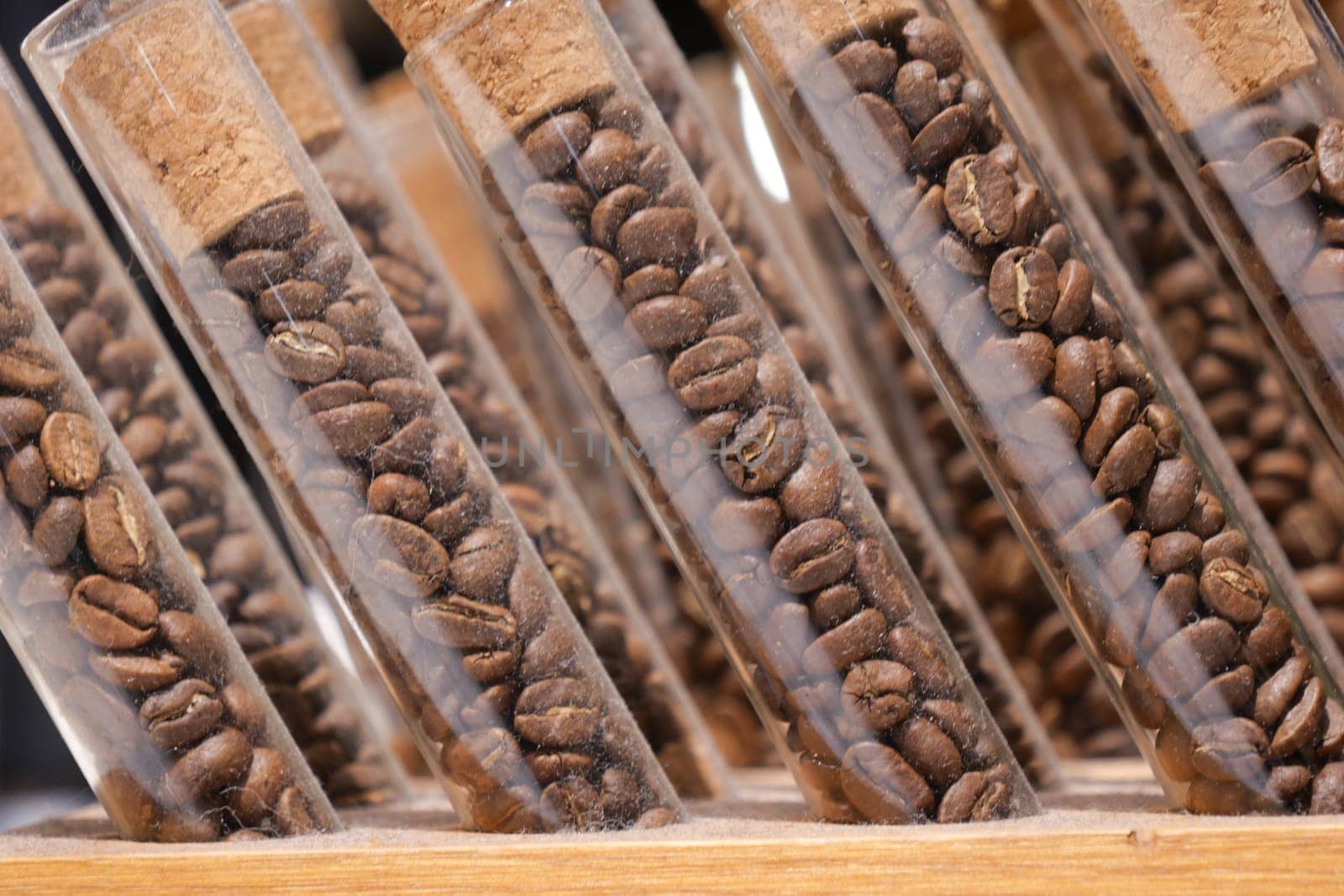 Test tubes filled with coffee beans on wooden shelf by towfiq007