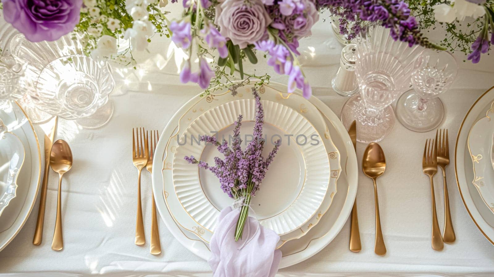 Wedding table decoration with lavender flowers, sweets, cake and candles