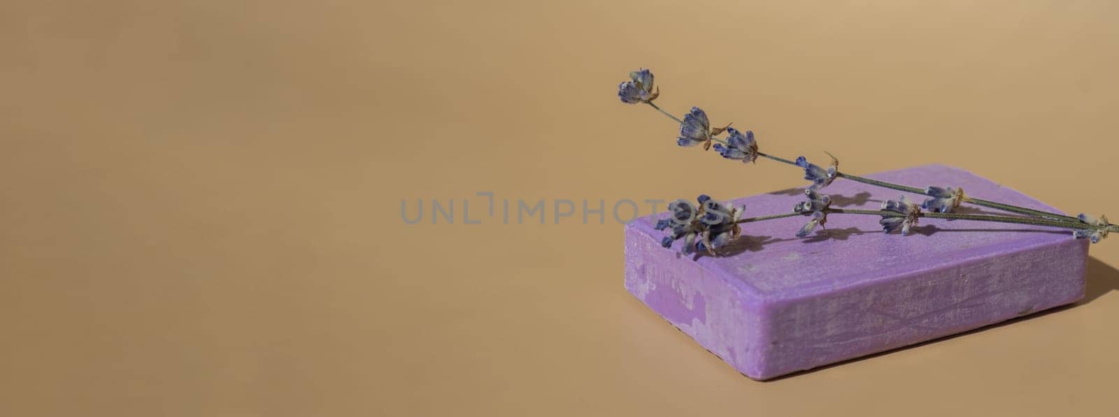 Lavender soap on beige background with copy space for your text. Advertisement template mock up. Skincare homemade natural cosmetic concept. Organic dry lavender flower. Handmade soap