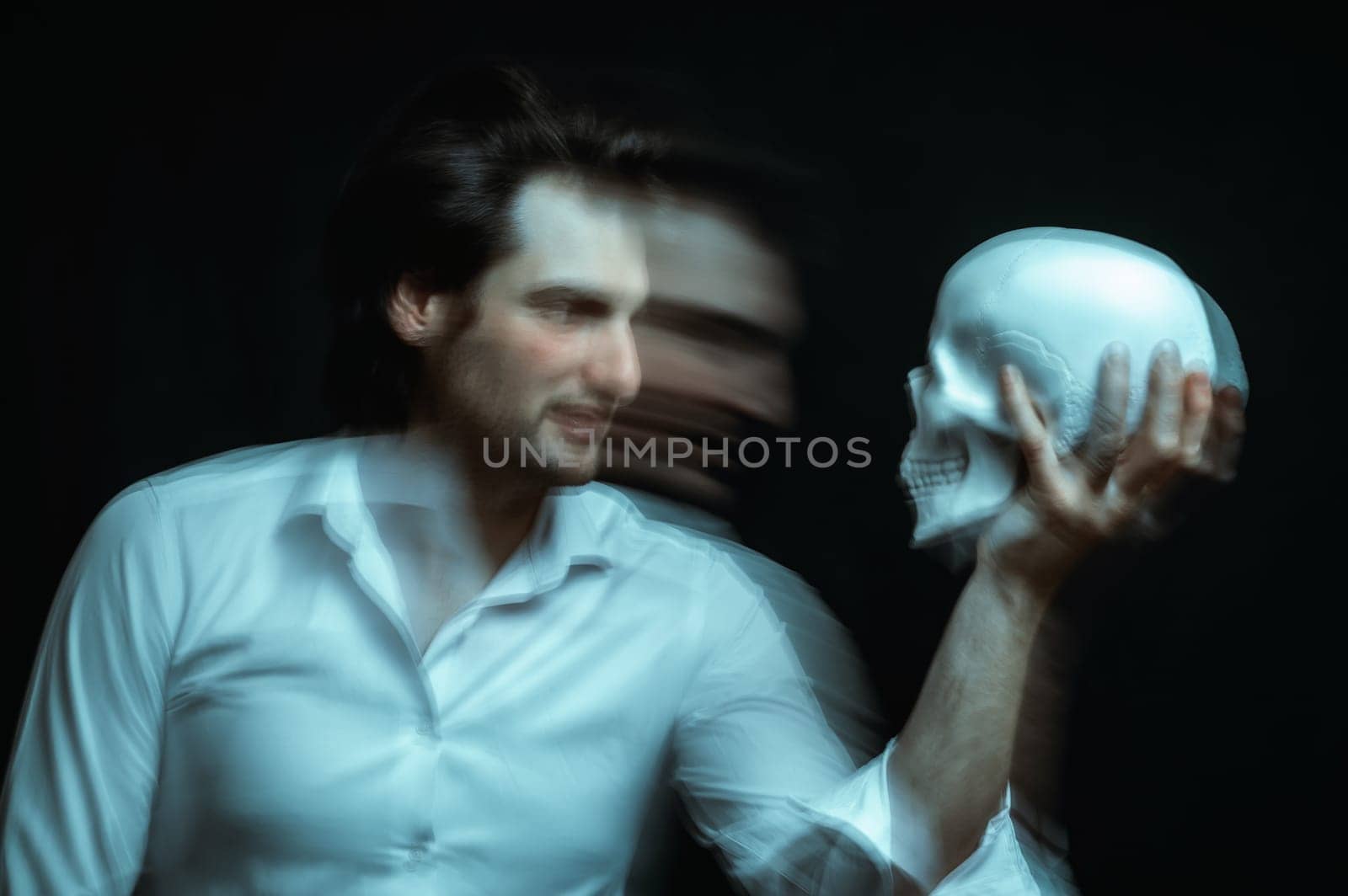 portrait of psychopathic man with mental disorders with a human skull in his hand