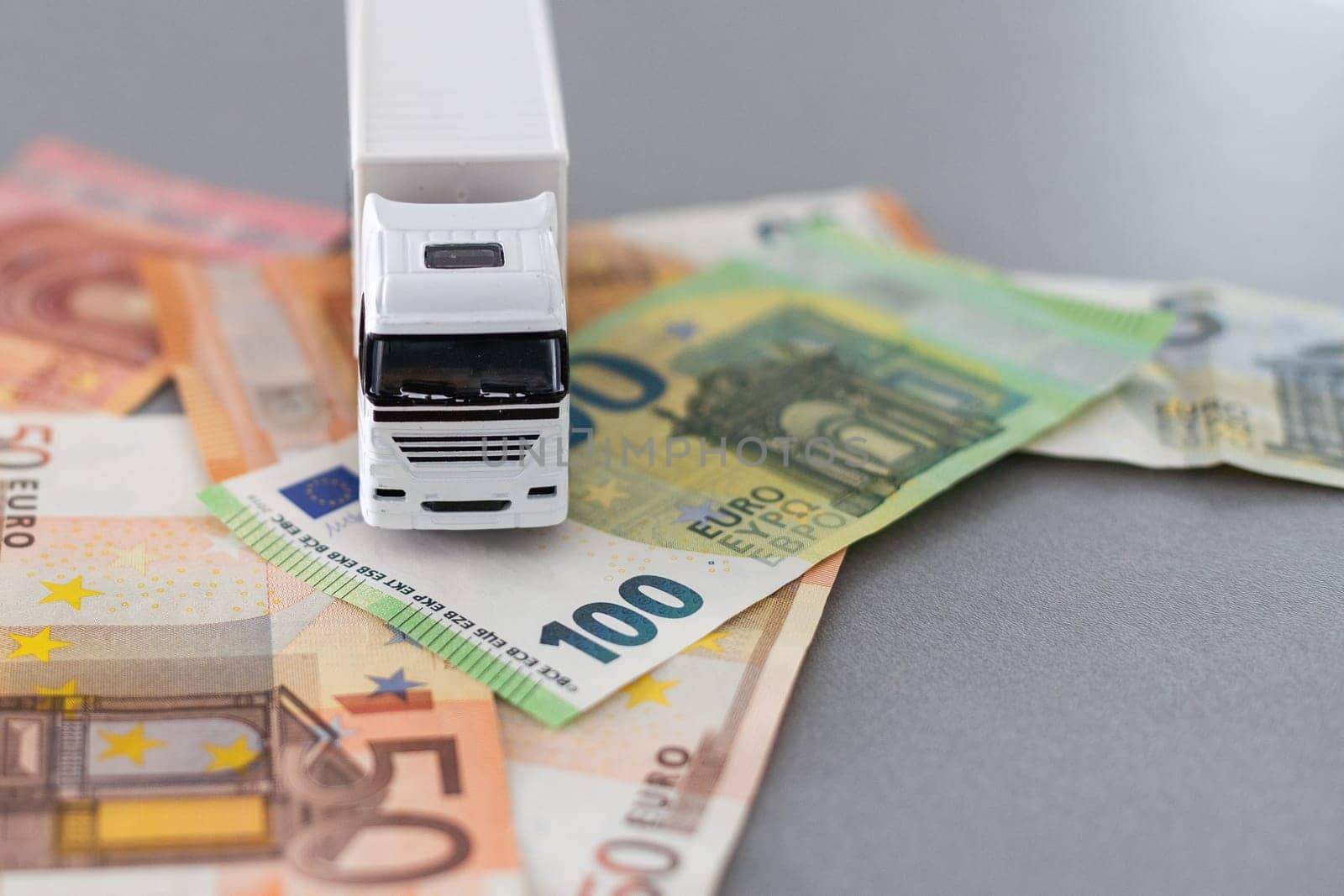 white toy truck on euro banknotes. concept for logistics, transportation and and finance by Andelov13