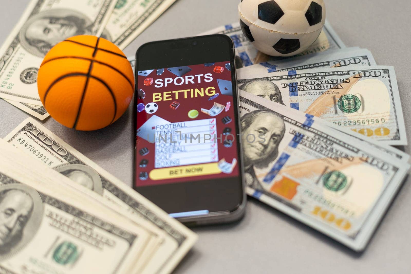 Smartphone with gambling mobile application and basketball ball with money close-up. Sport and betting concept. High quality photo