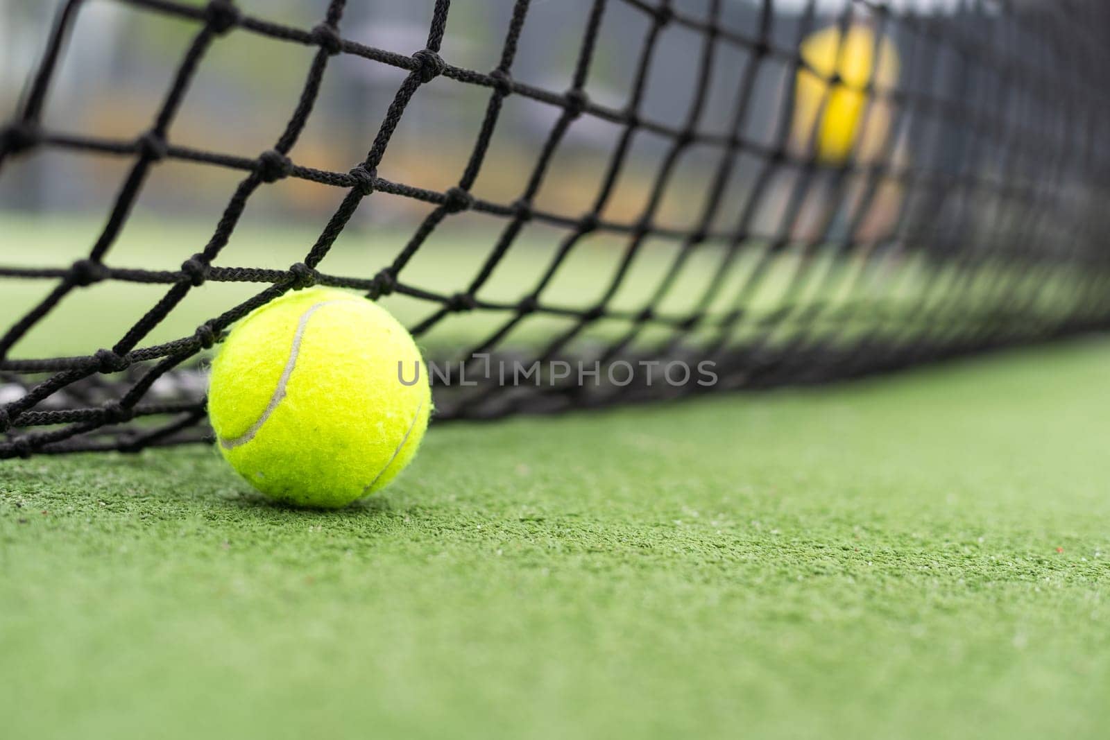 Tennis Ball on the Court against the Court Net. High quality photo