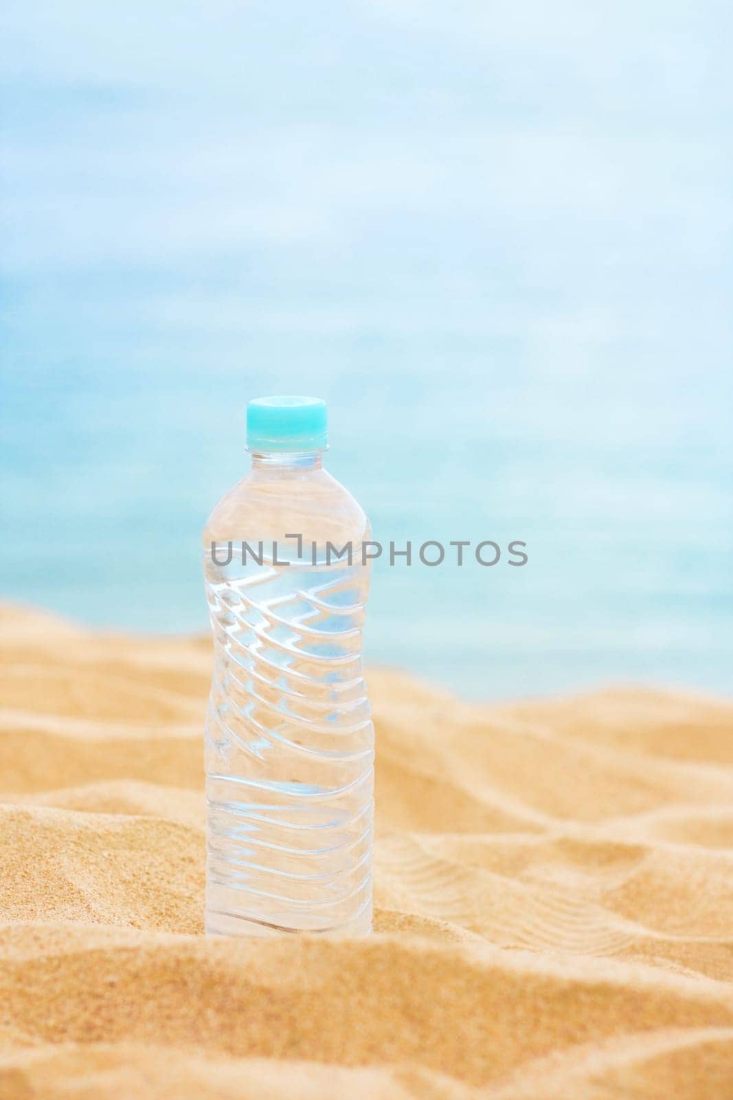 drinks, summertime and environment concept - bottle of water on the beach, elegant visuals