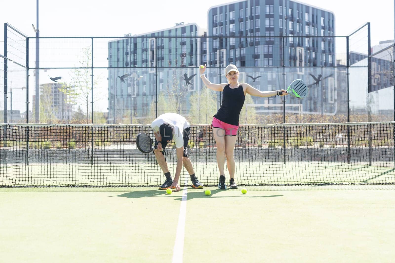 Young sporty woman and man playing padel together on same team. High quality photo