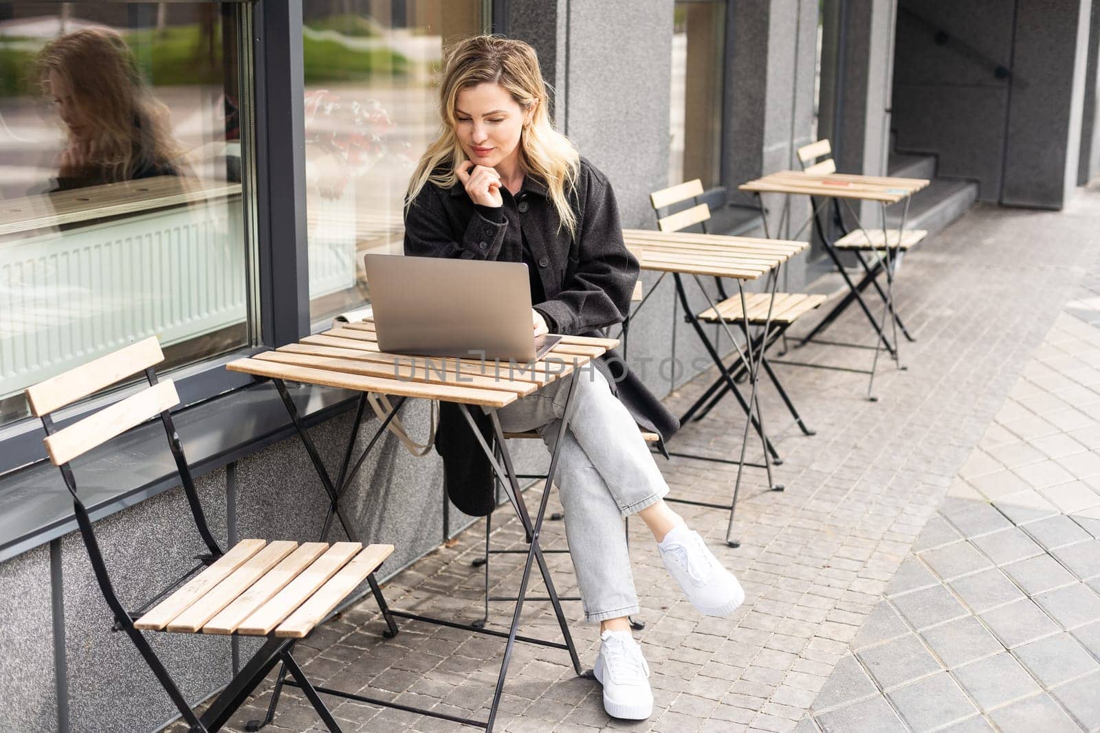 Young woman working at a remote job in a cafe by Andelov13